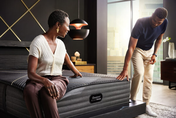 man and woman om beautyrest black mattress